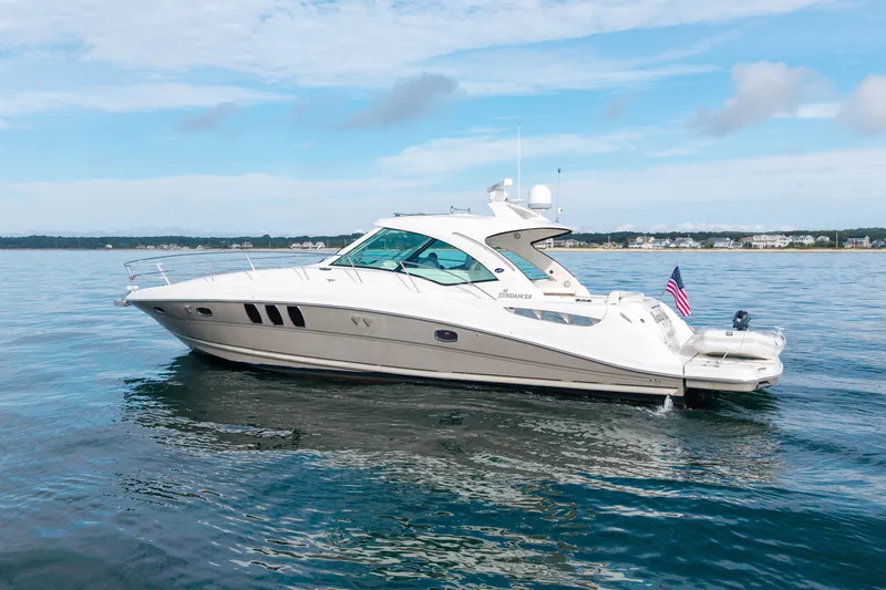 Slide: The Image of 2006 Sea Ray 48 Sundancer yacht cruising on calm waters under a clear sky. - 5