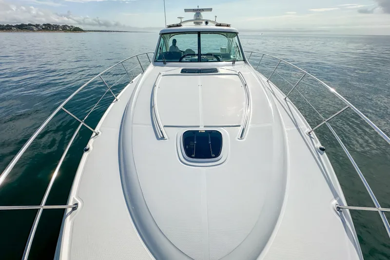 Slide: The Image of 2006 Sea Ray 48 Sundancer yacht cruising on calm waters, showcasing sleek design and spacious deck. - 57