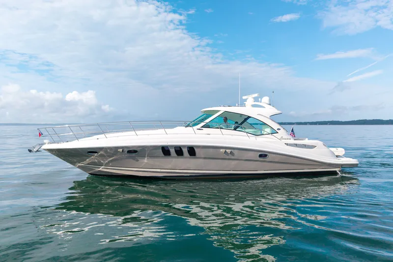 Slide: The Image of 2006 Sea Ray 48 Sundancer yacht cruising on calm waters under a clear sky. - 9