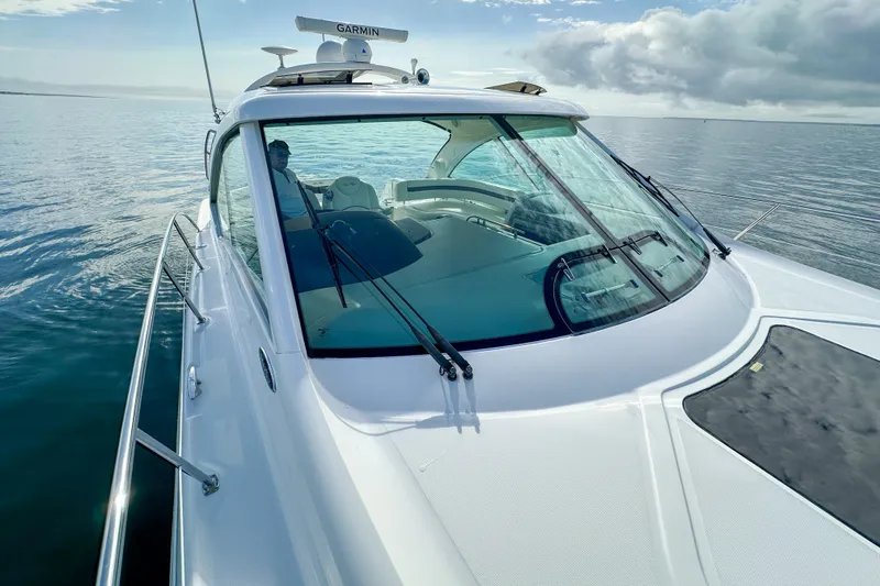 Slide: The Image of 2006 Sea Ray 48 Sundancer yacht cruising on calm waters under a cloudy sky. - 60