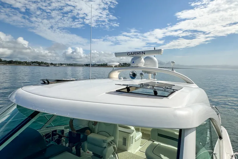 Slide: The Image of 2006 Sea Ray 48 Sundancer yacht with Garmin radar, cruising on calm waters under a blue sky. - 62
