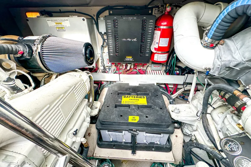 Slide: The Image of Engine room of a 2006 Sea Ray 48 Sundancer, featuring batteries and mechanical components. - 82