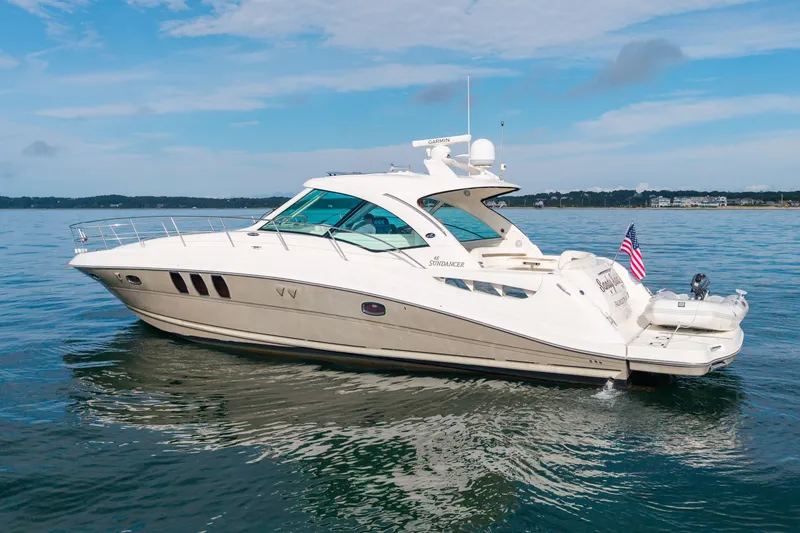 Slide: The Image of 2006 Sea Ray 48 Sundancer yacht cruising on calm waters under a clear sky. - 8