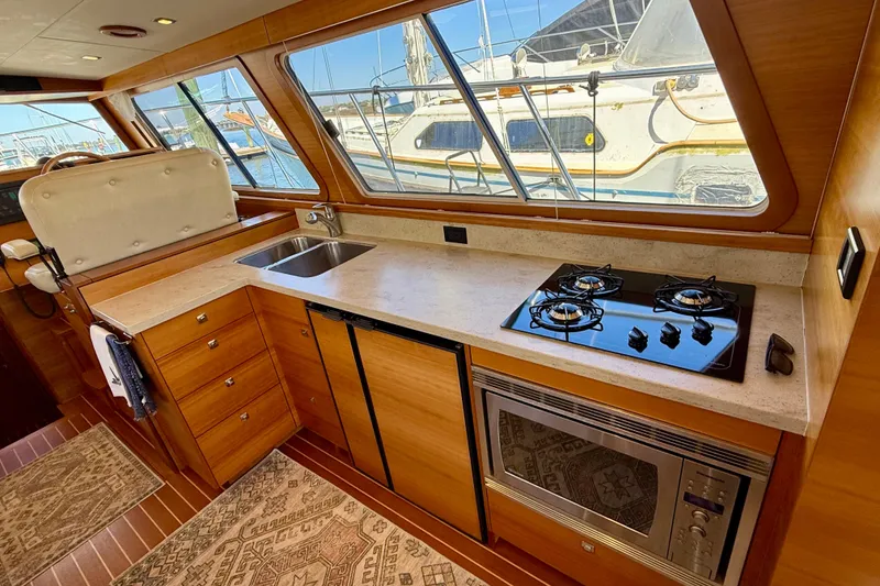 Slide: The Image of Luxurious 2015 Coastal Craft 45 yacht kitchen with stove, sink, and microwave. - 46