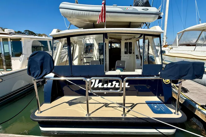 Slide: The Image of 2015 Coastal Craft 45 yacht docked, featuring covered equipment and an inflatable boat on top. - 13