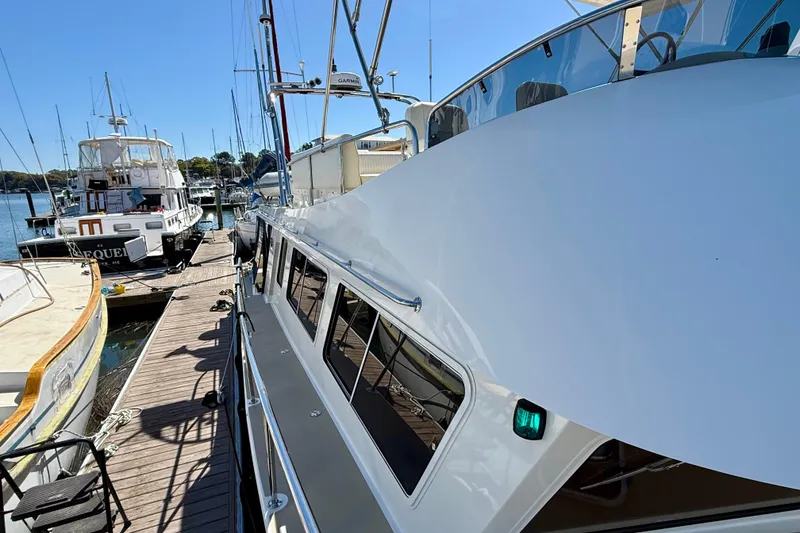 Slide: The Image of 2015 Coastal Craft 45 yacht docked at marina under clear blue sky. - 23