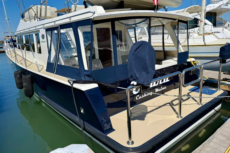 Slide: The Image of 2015 Coastal Craft 45 yacht docked in marina, featuring sleek design and spacious deck. - 14