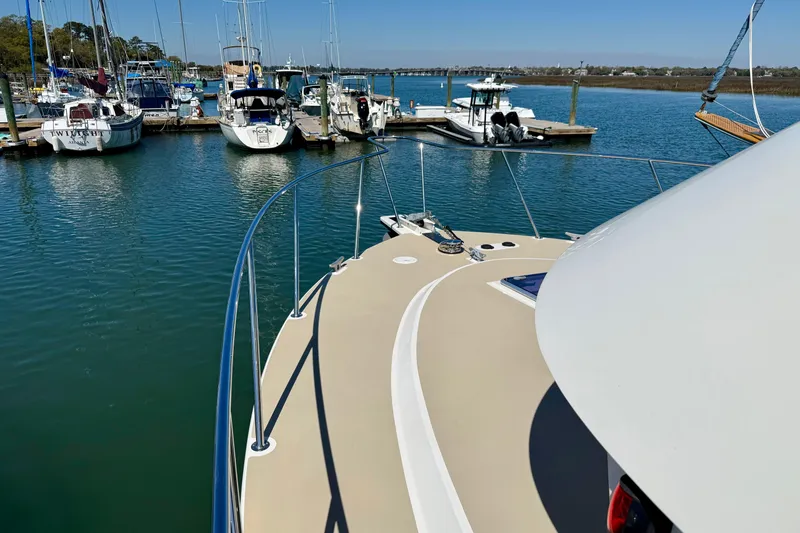 Slide: The Image of 2015 Coastal Craft 45 yacht docked in a serene marina with other boats. - 21