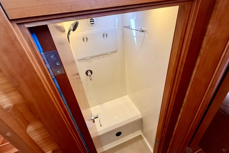 Slide: The Image of Compact shower area in 2015 Coastal Craft 45 yacht, featuring wooden door and modern fixtures. - 56