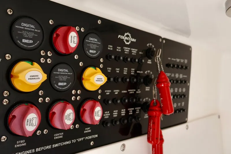 Slide: The Image of Control panel of 2023 Fountain 34 Tournament Edition boat with digital switches and safety keys. - 17
