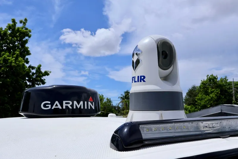 Slide: The Image of Garmin and FLIR equipment on 2023 Fountain 34 Tournament Edition boat under blue sky. - 13