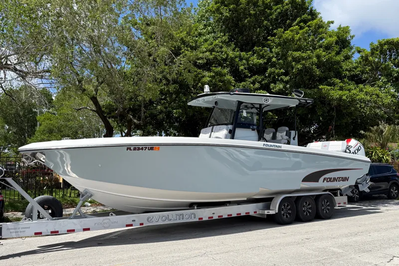 Slide: The Image of 2023 Fountain 34 Tournament Edition boat on trailer, surrounded by trees. - 2