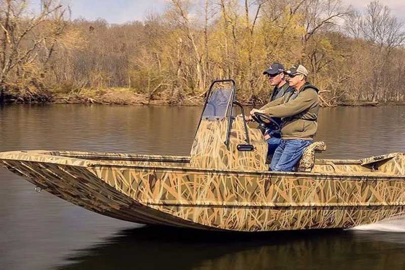 Slide: The Image of Two people navigating a 2027 Lowe Roughneck RX1760 Pathfinder boat on a calm river. - 3