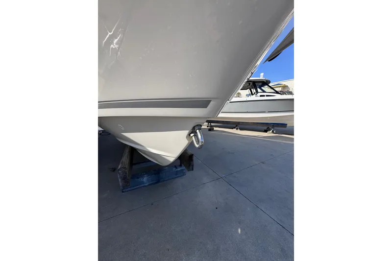 Slide: The Image of 2022 Boston Whaler 280 Vantage boat hull on display in a marina setting. - 43
