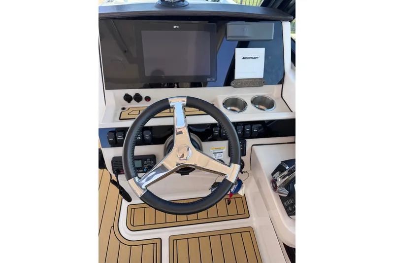 Slide: The Image of 2022 Boston Whaler 280 Vantage helm with steering wheel, touchscreen, and Mercury controls. - 18