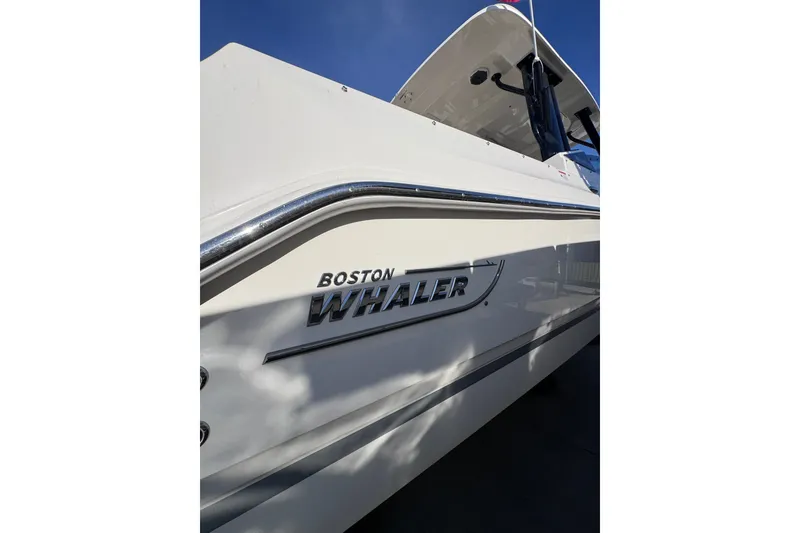Slide: The Image of 2022 Boston Whaler 280 Vantage boat side view with logo under clear sky. - 42