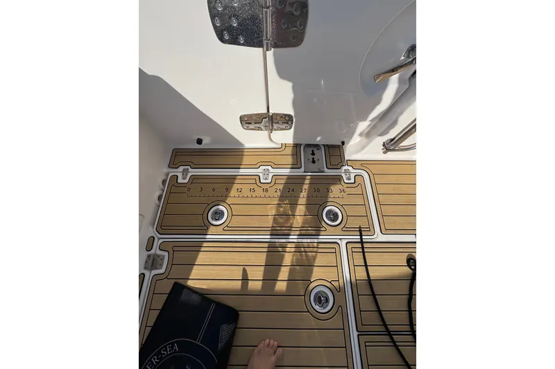 Slide: The Image of Deck of 2022 Boston Whaler 280 Vantage with teak-style flooring and measurement markings. - 14
