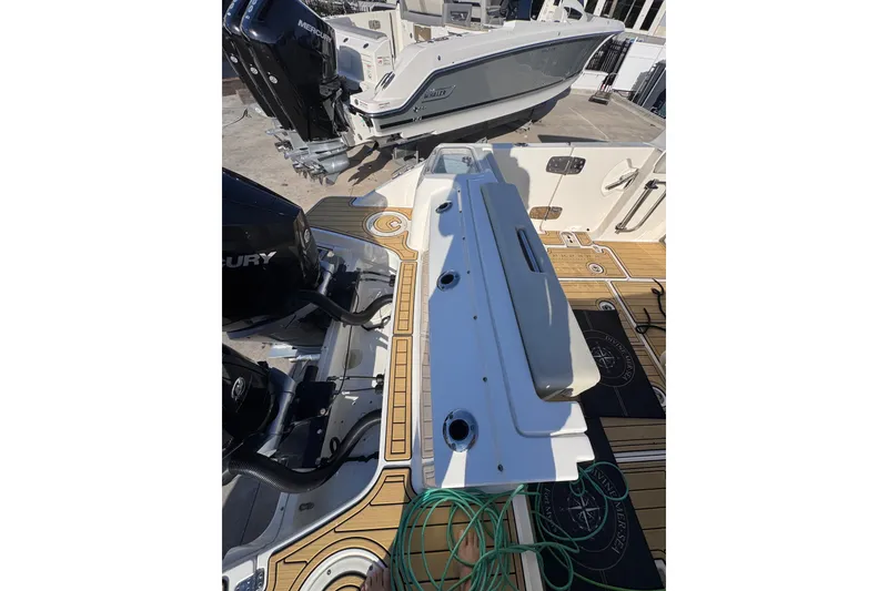 Slide: The Image of 2022 Boston Whaler 280 Vantage boat deck with Mercury engines and teak flooring. - 34