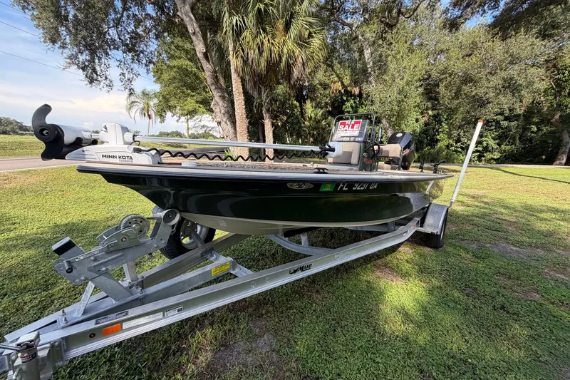 Slide: The Image of 2025 Mako 18 Pro Skiff Backwater Edition on trailer, for sale, parked on grass. - 2