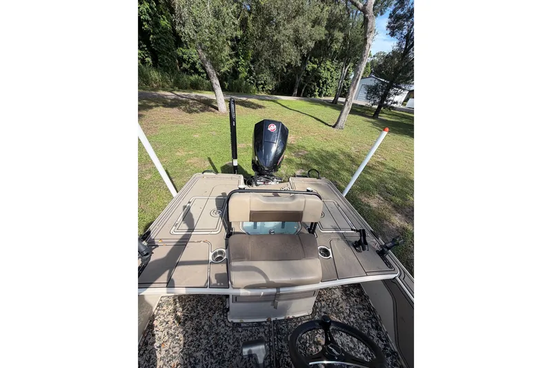Slide: The Image of 2025 Mako 18 Pro Skiff Backwater Edition boat with motor, parked on grass. - 6