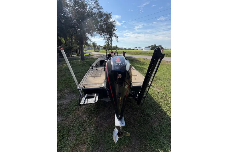 Slide: The Image of 2025 Mako 18 Pro Skiff Backwater Edition boat with powerful outboard motor, parked on grass. - 12