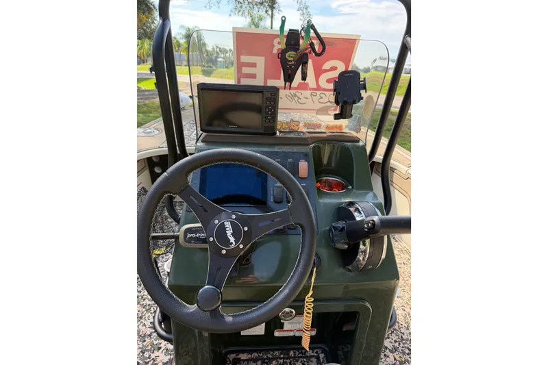 Slide: The Image of 2025 Mako 18 Pro Skiff Backwater Edition dashboard with steering wheel and navigation system. - 10