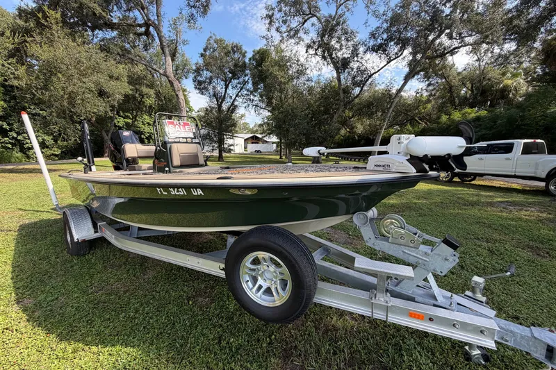 Slide: The Image of 2025 Mako 18 Pro Skiff Backwater Edition boat on trailer, for sale in grassy area. - 3