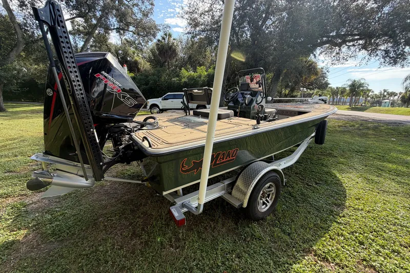 Slide: The Image of 2025 Mako 18 Pro Skiff Backwater Edition boat on trailer, parked on grass. - 4
