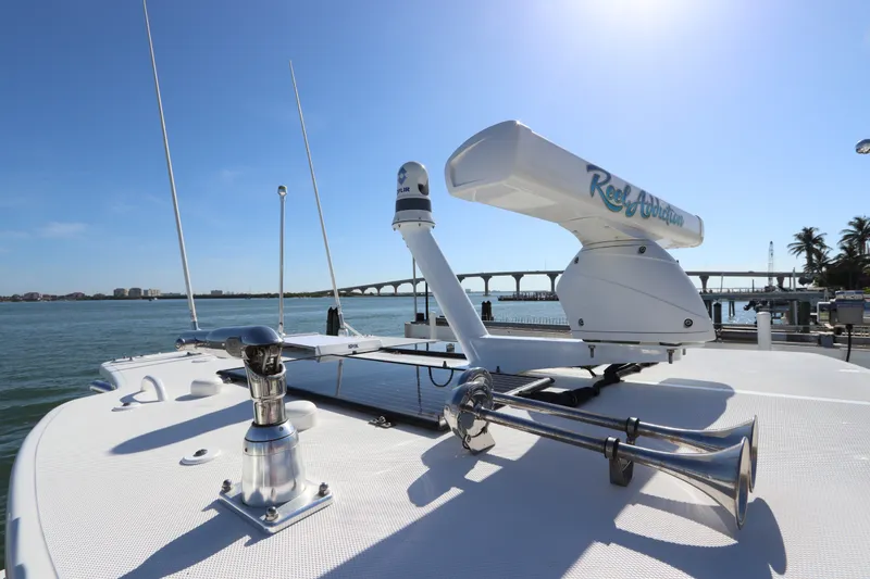 Slide: The Image of 2021 Edgewater 370CC boat deck with radar and antennas, overlooking a scenic waterfront. - 50