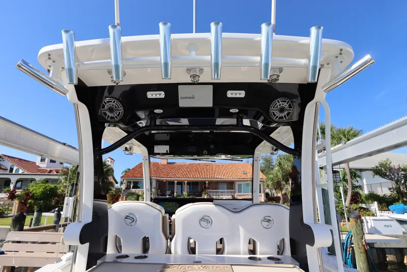 Slide: The Image of 2021 Edgewater 370CC boat with rod holders and Garmin electronics, docked under clear blue sky. - 25