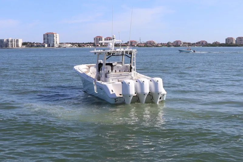 Slide: The Image of Edgewater 370CC 2021 boat cruising on a sunny day near coastal buildings. - 4