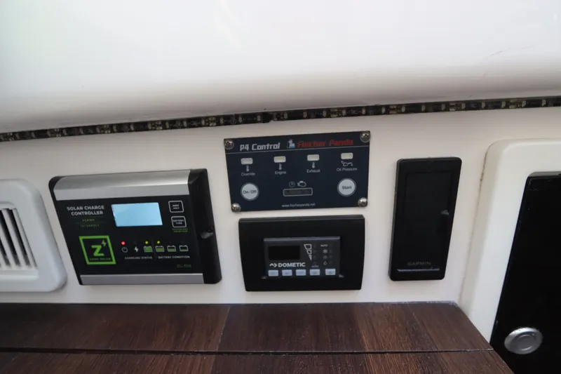 Slide: The Image of Control panel on 2021 Edgewater 370CC boat featuring solar charge controller and Fischer Panda system. - 61
