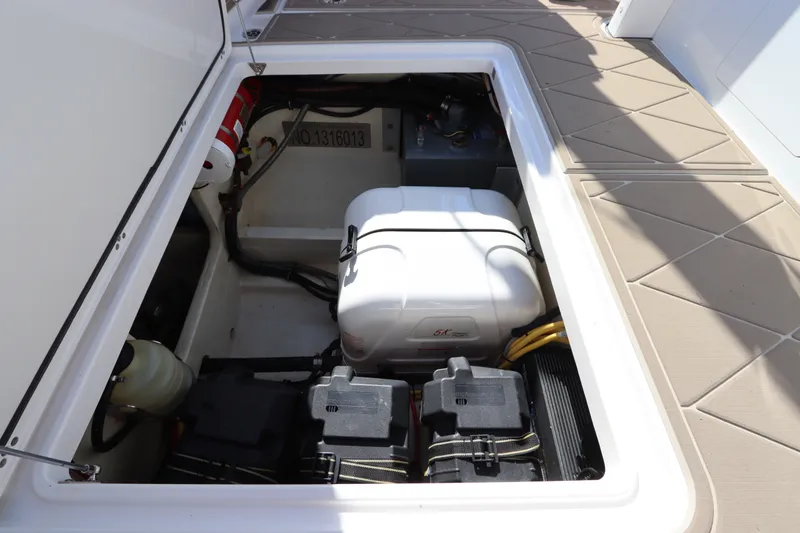 Slide: The Image of Open hatch of 2021 Edgewater 370CC boat showing engine compartment and equipment. - 18
