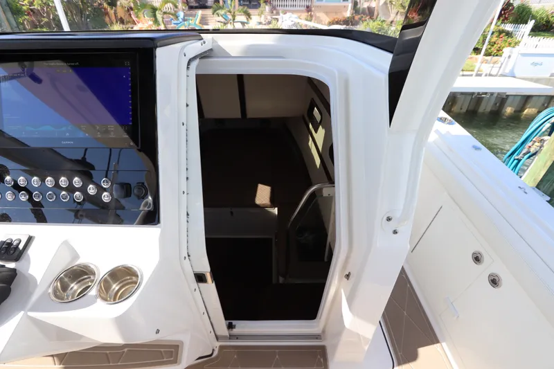 Slide: The Image of Edgewater 370CC 2021 boat cockpit with control panel and cabin entrance. - 54