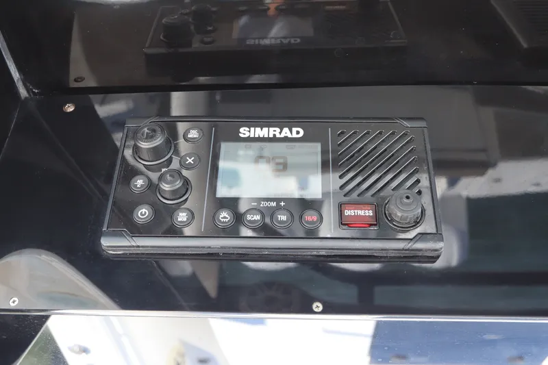 Slide: The Image of Simrad marine radio on 2021 Edgewater 370CC boat dashboard, featuring distress button. - 38