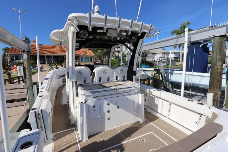 Slide: The Image of 2021 Edgewater 370CC boat docked, showcasing spacious deck and seating area. - 24