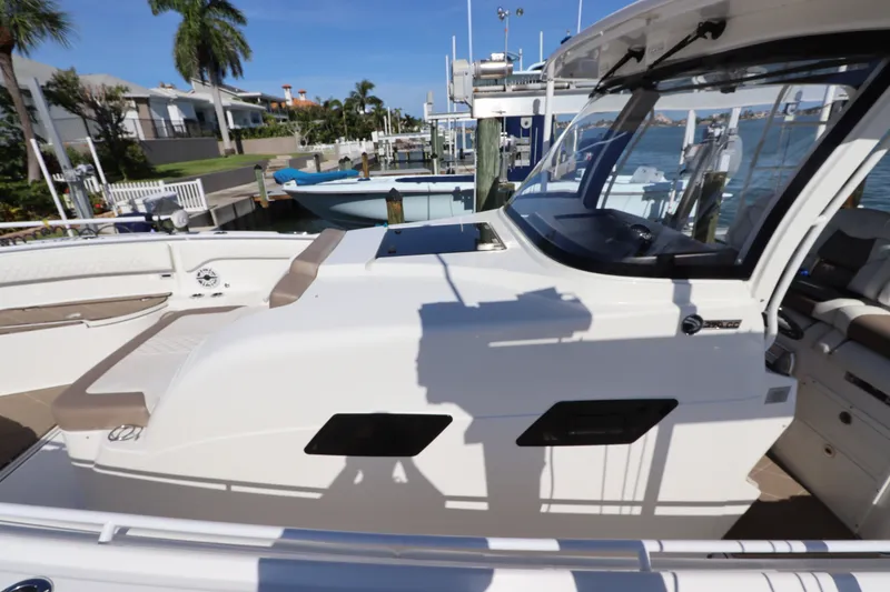 Slide: The Image of 2021 Edgewater 370CC boat docked, showcasing sleek design and spacious seating area. - 52