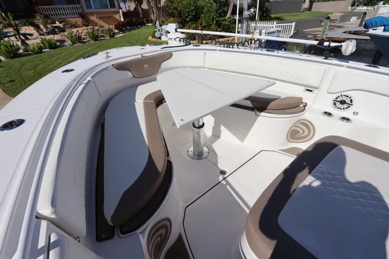 Slide: The Image of 2021 Edgewater 370CC boat interior with seating and table in a sunny setting. - 43