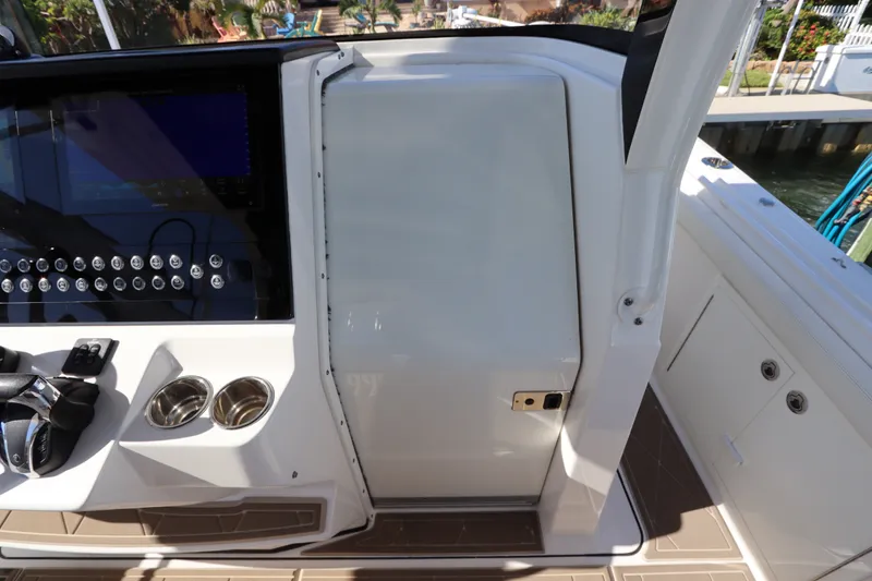 Slide: The Image of 2021 Edgewater 370CC boat console with steering wheel, controls, and cup holders. - 53