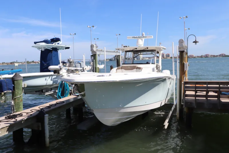 Slide: The Image of 2021 Edgewater 370CC boat docked at marina with clear blue sky. - 63