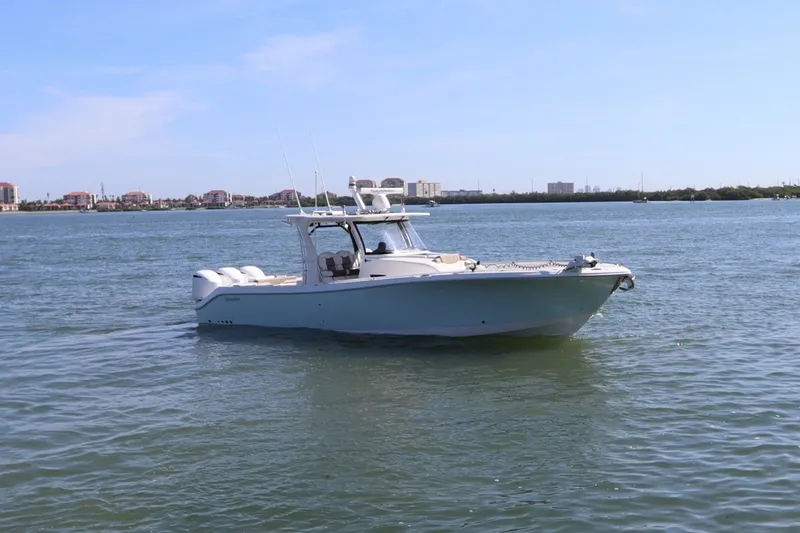Slide: The Image of 2021 Edgewater 370CC boat cruising on calm waters under a clear blue sky. - 3