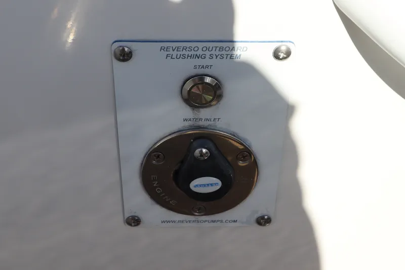 Slide: The Image of Reverso outboard flushing system on 2021 Edgewater 370CC boat, featuring water inlet and start button. - 10