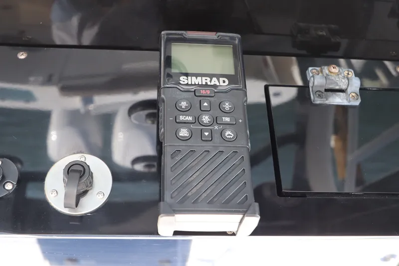 Slide: The Image of Simrad marine radio on 2021 Edgewater 370CC boat dashboard, featuring control buttons and display. - 39