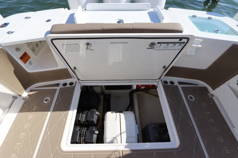 Slide: The Image of 2021 Edgewater 370CC boat storage compartment with open hatch, revealing interior equipment. - 17