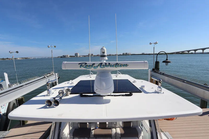 Slide: The Image of Edgewater 370CC 2021 boat docked with clear blue sky and bridge in background. - 49