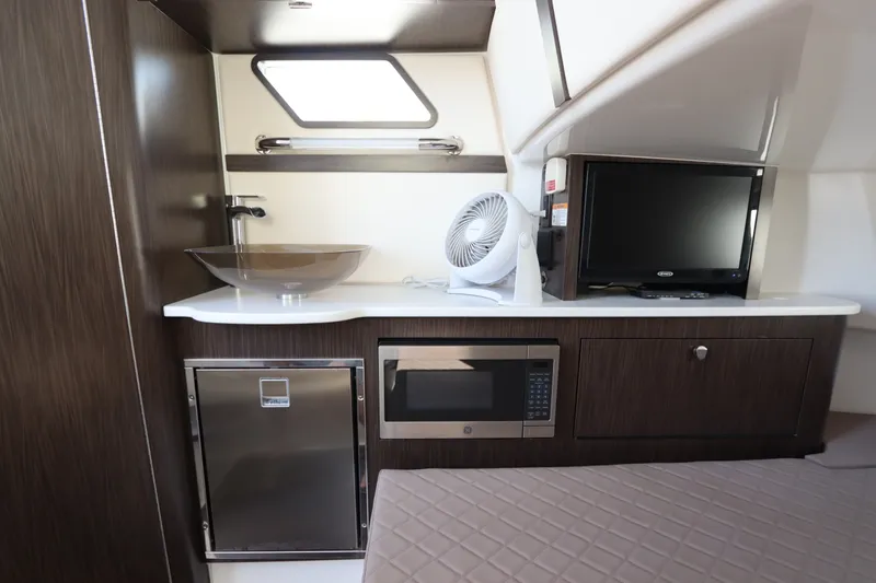 Slide: The Image of 2021 Edgewater 370CC cabin interior with sink, microwave, TV, and fan. - 57