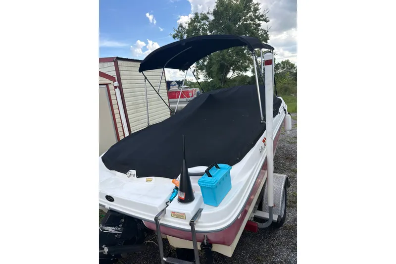 Slide: The Image of 2004 Sea Ray 180 Sport boat with cover and canopy, parked outdoors. - 3