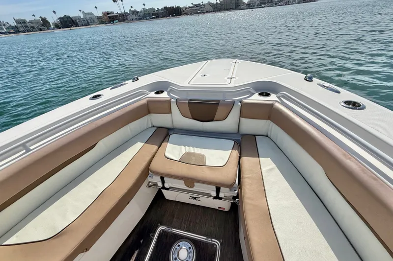 Slide: The Image of 2018 Wellcraft 302 Fisherman boat interior with cushioned seating, overlooking calm waters. - 13