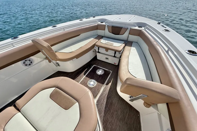 Slide: The Image of Interior view of 2018 Wellcraft 302 Fisherman boat with cushioned seating and ocean backdrop. - 14