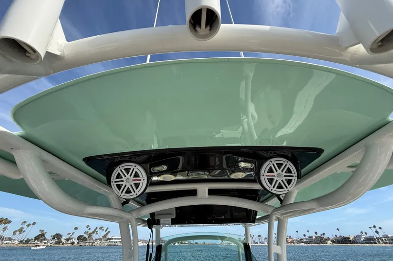 Slide: The Image of 2018 Wellcraft 302 Fisherman boat with speakers, viewed from below, against a coastal backdrop. - 23
